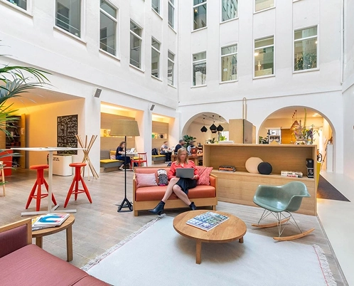 Modern office space with people working and relaxing in an open, airy environment.