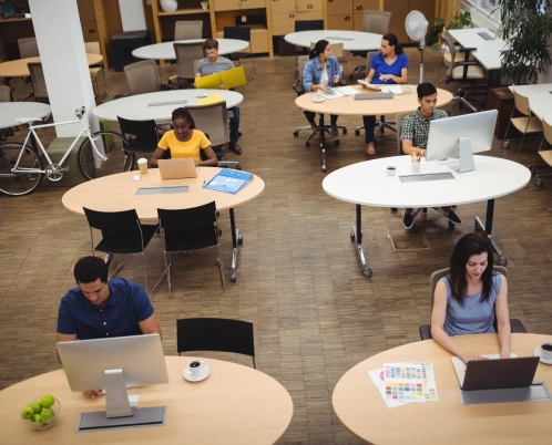 An open office space with people working at desks using computers.