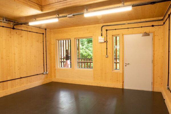 Interior of a wooden room with windows and a door at Abbott Road 384, London.