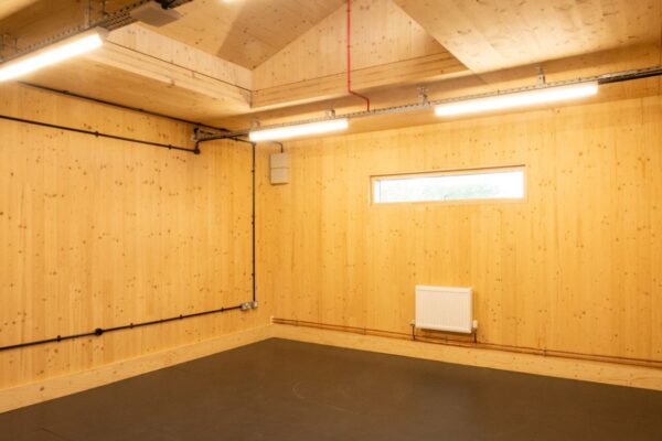 A room with light wood walls, a high ceiling, and strip lighting on Abbott Road 384, London.
