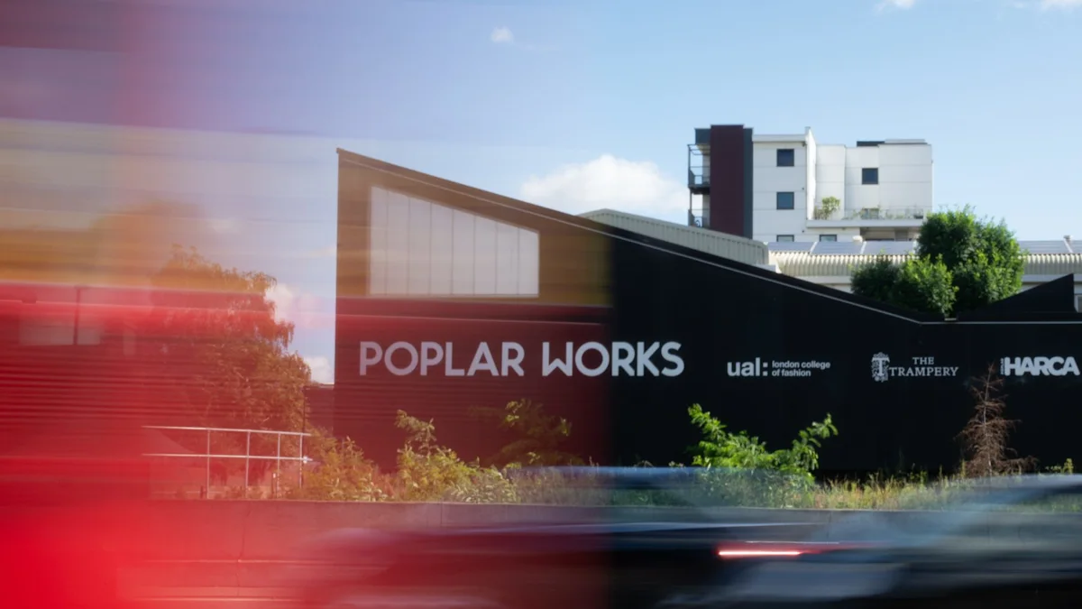 Poplar Works building with brand signage and blurred motion of passing cars in the foreground.