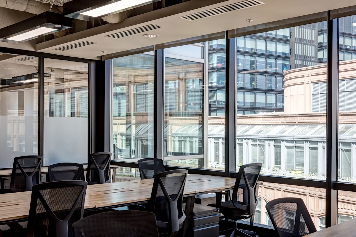 Modern office interior with large windows overlooking buildings on Appold Street, London.