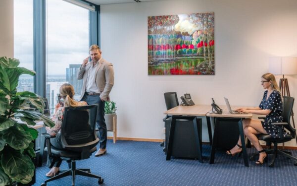 Modern office space with three people working at Bank Street 40, London.
