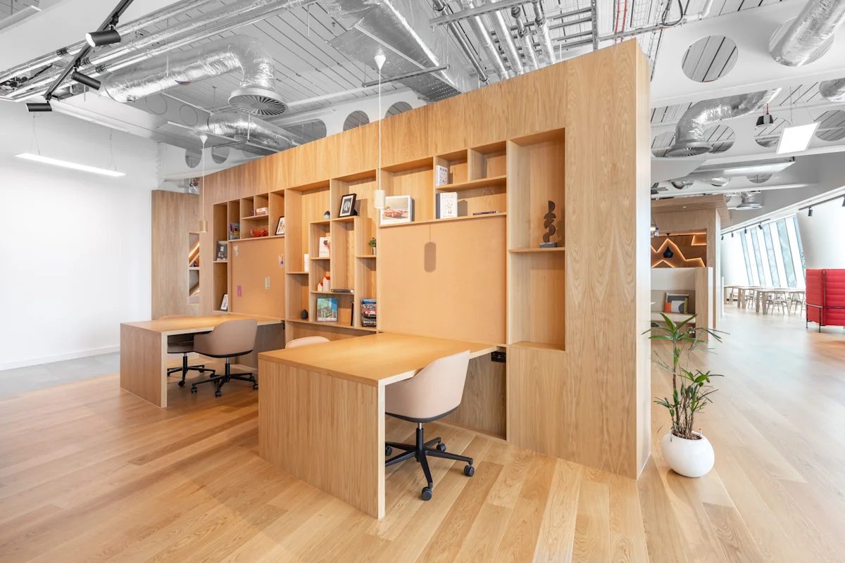 Modern office space with wooden desks and shelves at 100 Bishopsgate, London.