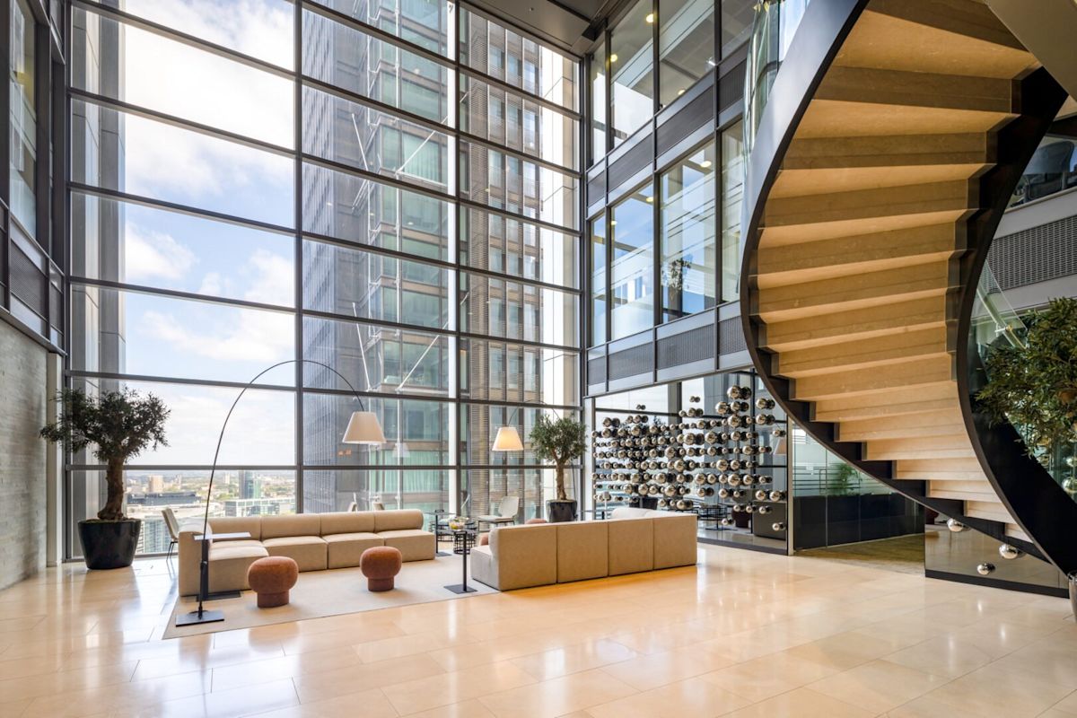 Modern office interior at 110 Bishopsgate, London, featuring a spiral staircase and large glass windows.