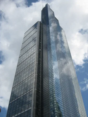 A tall, modern skyscraper with reflective glass windows, known as Bishopsgate 110 London, against a cloudy sky.