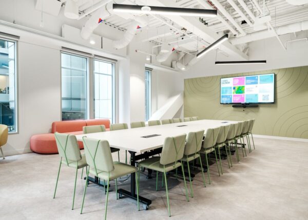 A modern conference room at 199 Bishopsgate, London, featuring a long table, chairs, and a wall-mounted display.