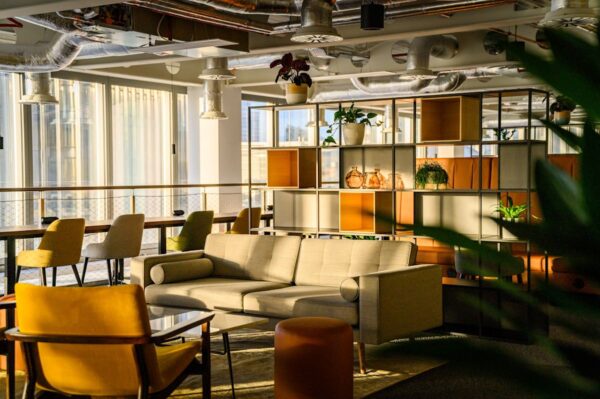 A modern, sunlit office lounge area with stylish furniture and shelving at Bishopsgate 22, London.