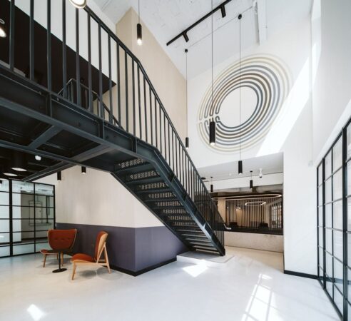 Modern office interior with a black metal staircase and abstract wall art at Bishopsgate 222 B London.