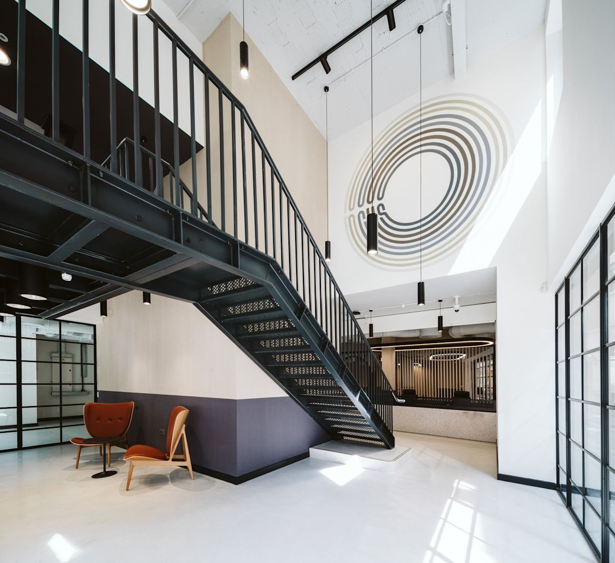 Modern office interior with a black metal staircase and abstract wall art at Bishopsgate 222 B London.