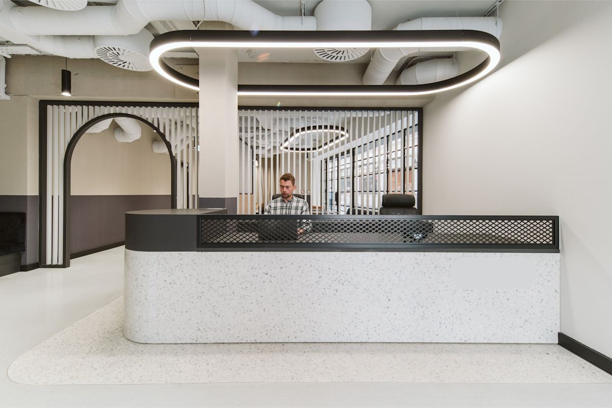 A modern reception area at Bishopsgate 222 B London with a person behind the desk.