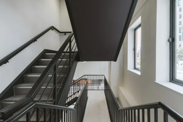 A modern interior stairway with black railings and two large windows at Bishopsgate 222 B, London.