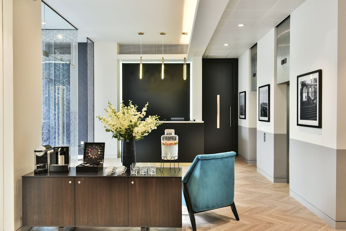 Modern office reception area at Bishopsgate 288 London with a coffee station and decorative plants.