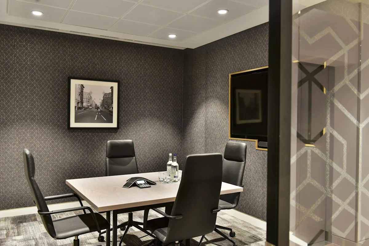 A modern conference room with a table, chairs, and monochrome artwork on the wall.