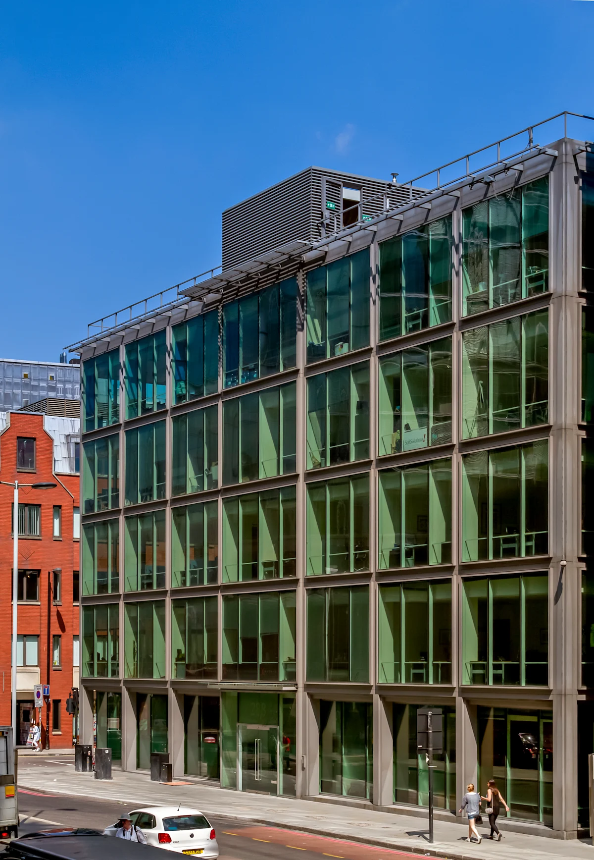 The image shows the modern glass facade of the building at 288 Bishopsgate, London, on a sunny day.