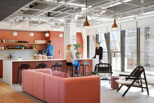 A modern office lounge area with people interacting near a kitchen counter at Broadwick Street 33, London.