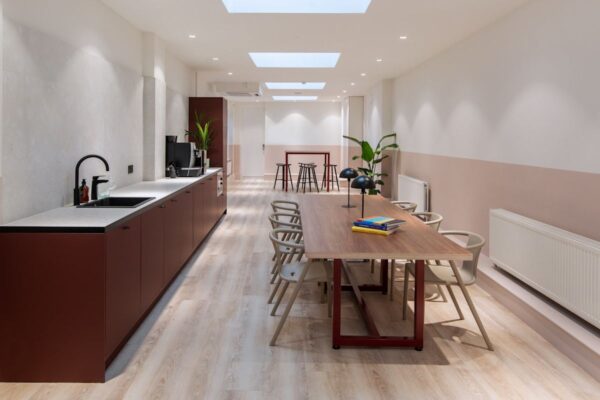 A modern communal kitchen and dining area with sleek furnishings and light wood flooring at Broadwick Street 45, London.