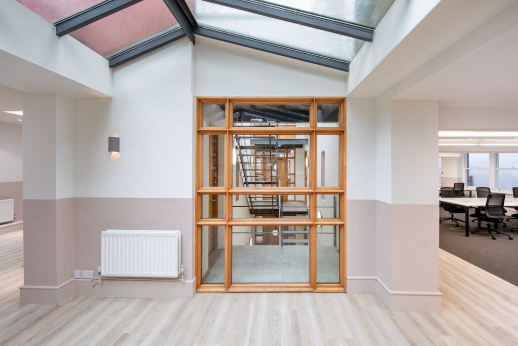 Modern office interior with a wooden-framed glass partition and visible stairway at Broadwick Street 45, London.