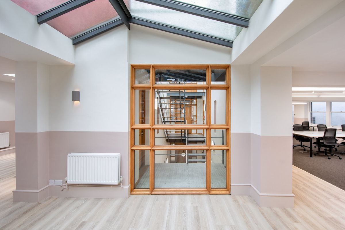 Modern office interior with a wooden-framed glass partition and visible stairway at Broadwick Street 45, London.
