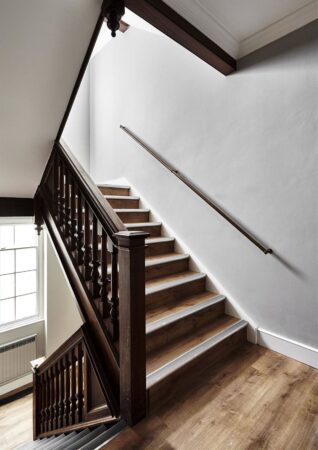 Wooden staircase with a handrail and a window at Broadwick Street, London.