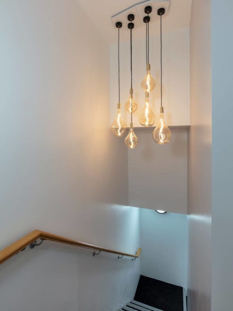 A modern staircase with hanging light bulbs on Broadwick Street, London.
