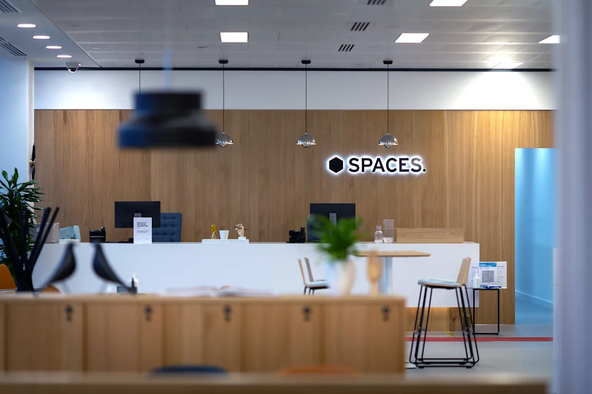 Modern office reception area at Spaces in Cabot Square, London with a welcoming desk and seating.