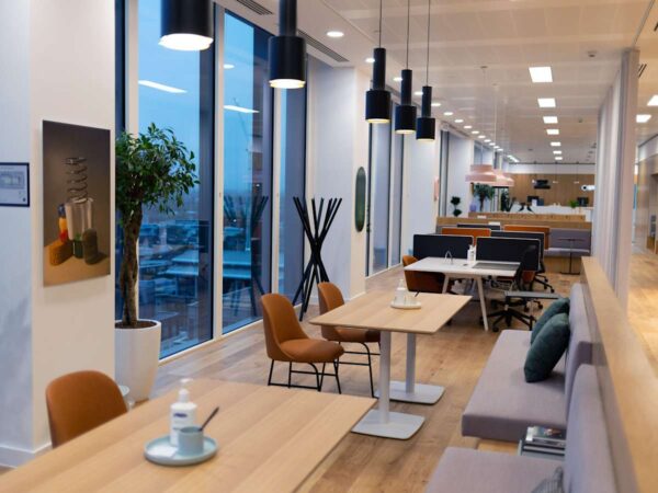 Modern office space at Cabot Square 25, London, featuring desks, chairs, and large windows.