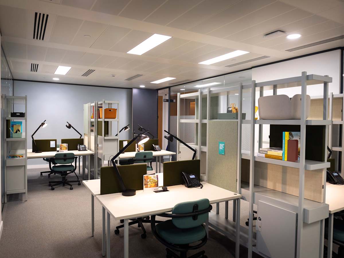Modern office space with multiple workstations and desks at Cabot Square 25, London.