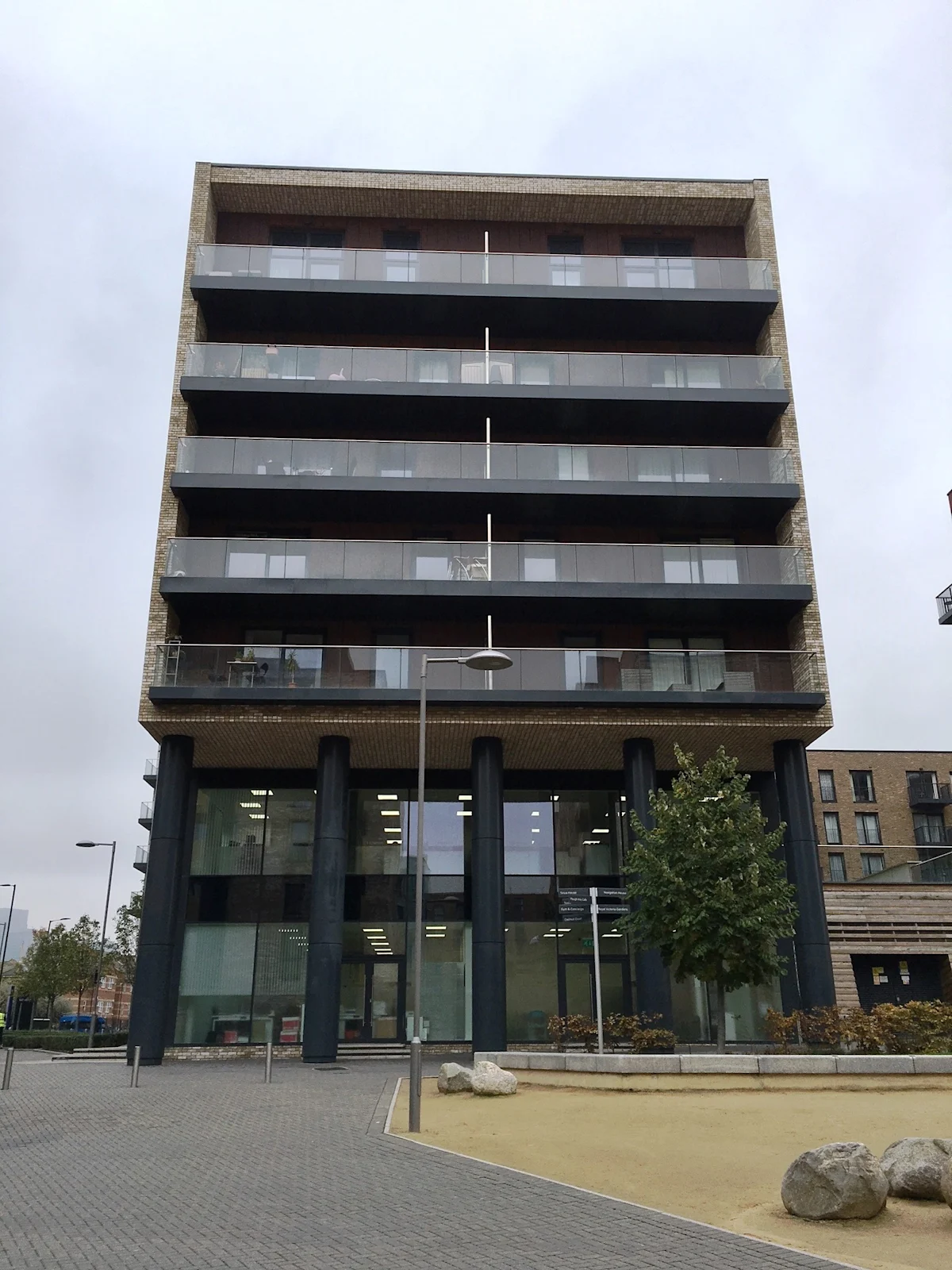 A modern multi-story building with large glass windows and balconies, located at Cadmus Court Ground Floor in London.