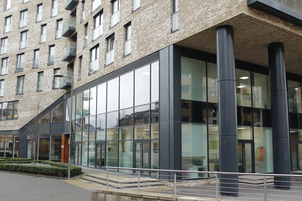 The ground floor of Cadmus Court in London, featuring large glass windows and modern architecture.