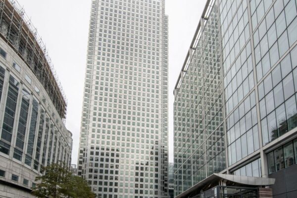 A view of the skyscraper at Canada Square 1, London, surrounded by modern glass buildings.