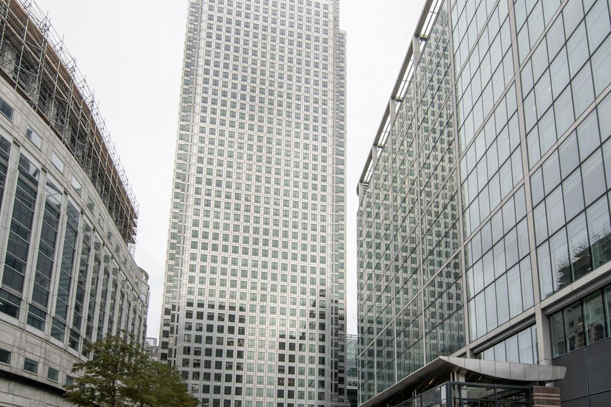 A view of the skyscraper at Canada Square 1, London, surrounded by modern glass buildings.