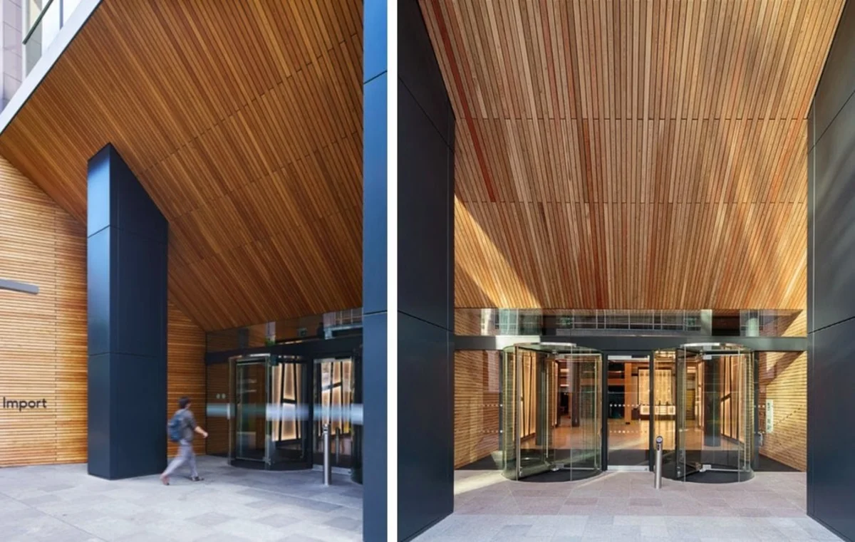 Entrance of a modern office building in Clove Crescent, London, with wood-paneling and revolving doors.