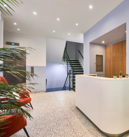 Modern office lobby with a reception desk, stairs, and seating area at Crown Place 4, London.