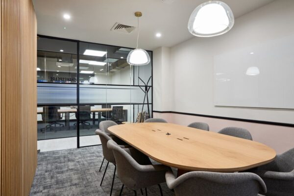 Modern conference room with a wooden table and gray chairs at Crown Place, London.