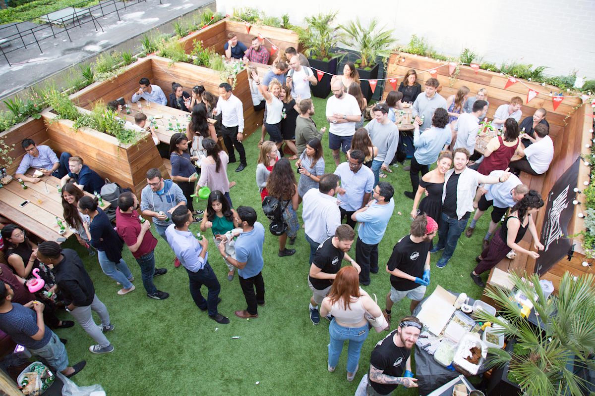 A lively rooftop gathering with people socializing and enjoying drinks at Curtain Road, London.