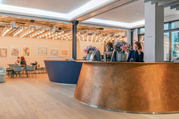 Modern lobby interior at 35-41 Folgate Street, London, featuring a curved reception desk and lounge area.