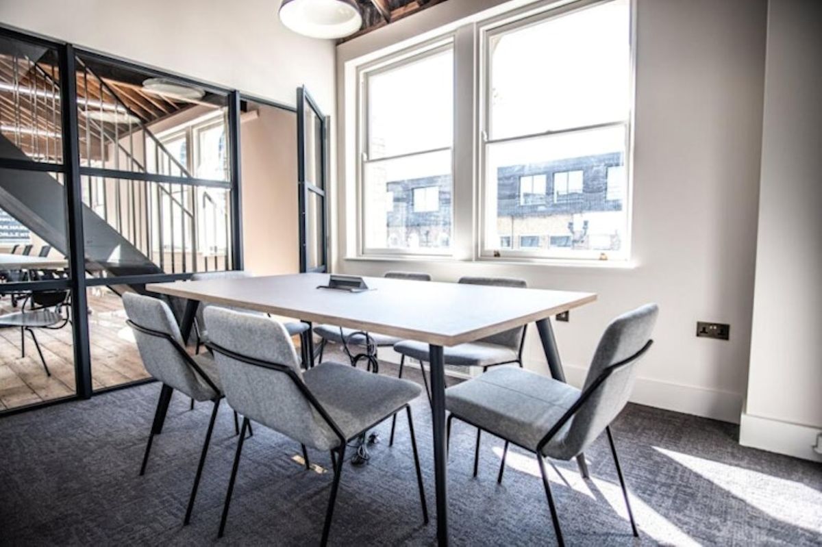 A modern conference room with a large table and gray chairs at Great Eastern Street 40, London.