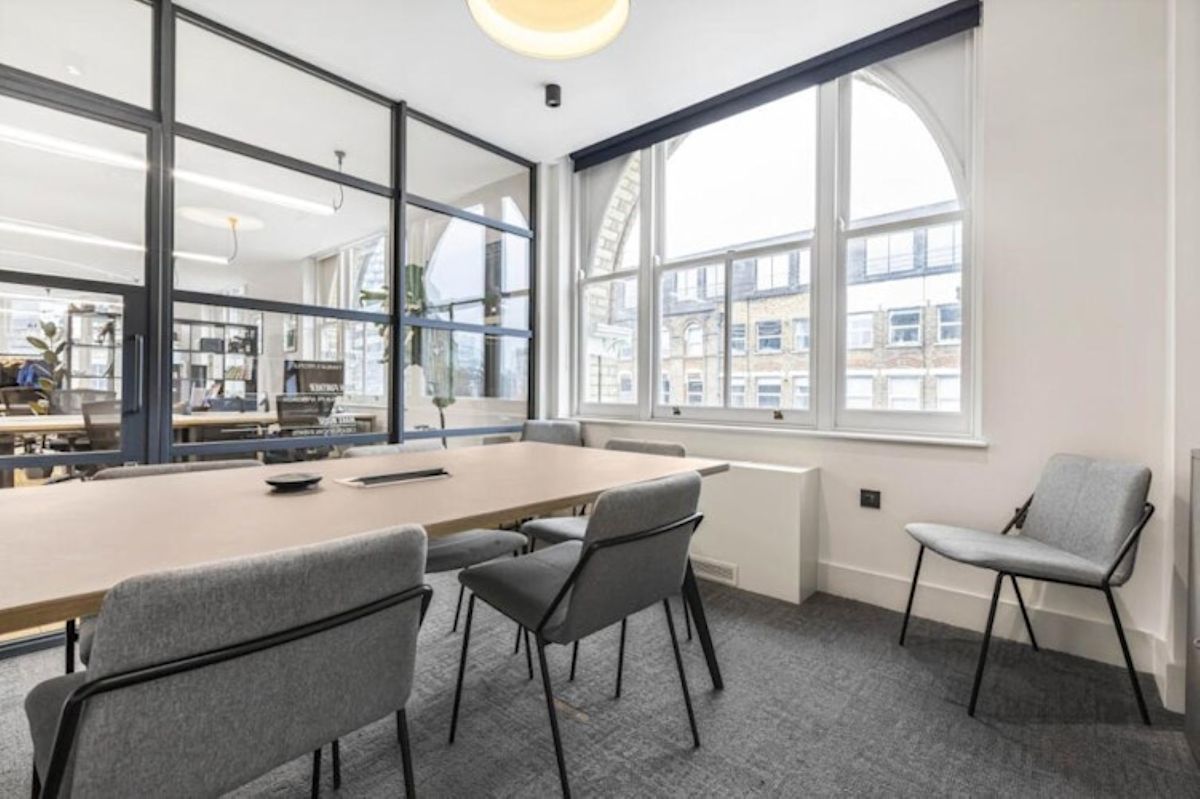 A modern meeting room in an office on Great Eastern Street, London, featuring a large table, chairs, and a window view.