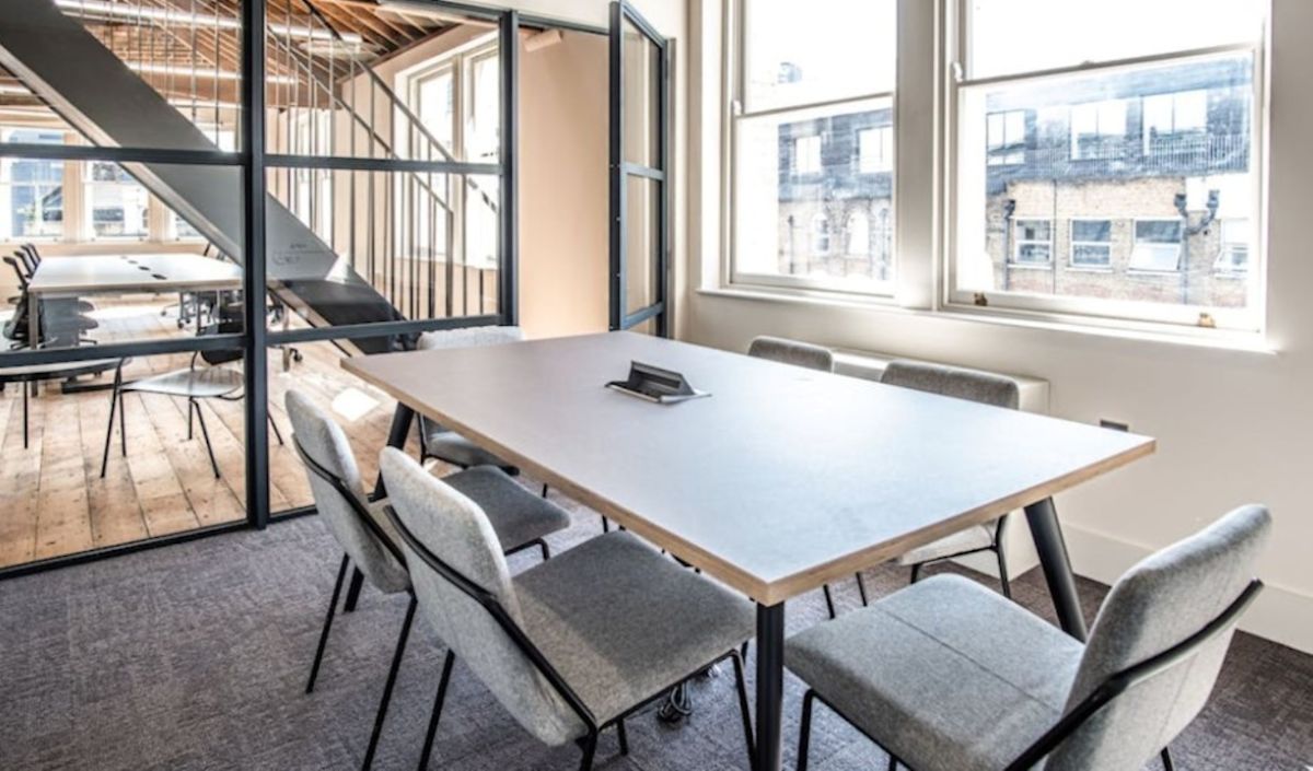 A modern office meeting room with a large table and chairs, located on Great Eastern Street in London.