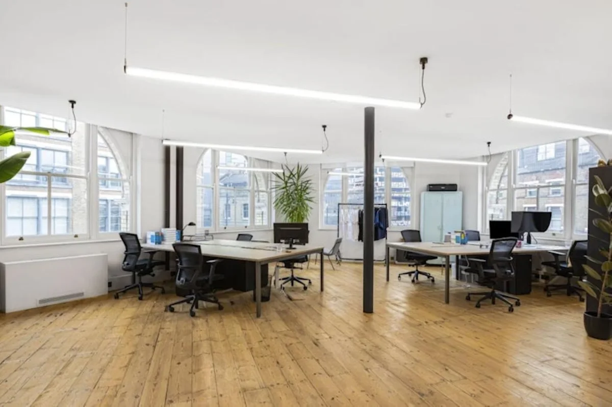 A spacious and modern open-plan office with wooden floors and large windows at 40 Great Eastern Street, London.