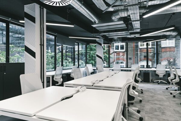 Modern open-plan office space with white desks and chairs at Ingestre Place, London.