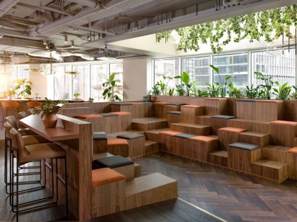 A modern open space with tiered wooden seating and plants at Liverpool Street, London.