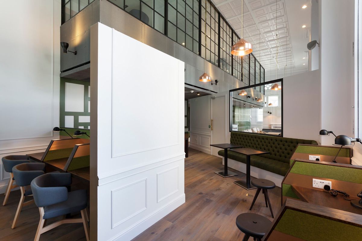 Modern office space with green seating and individual workstations at Liverpool Street 50, London.