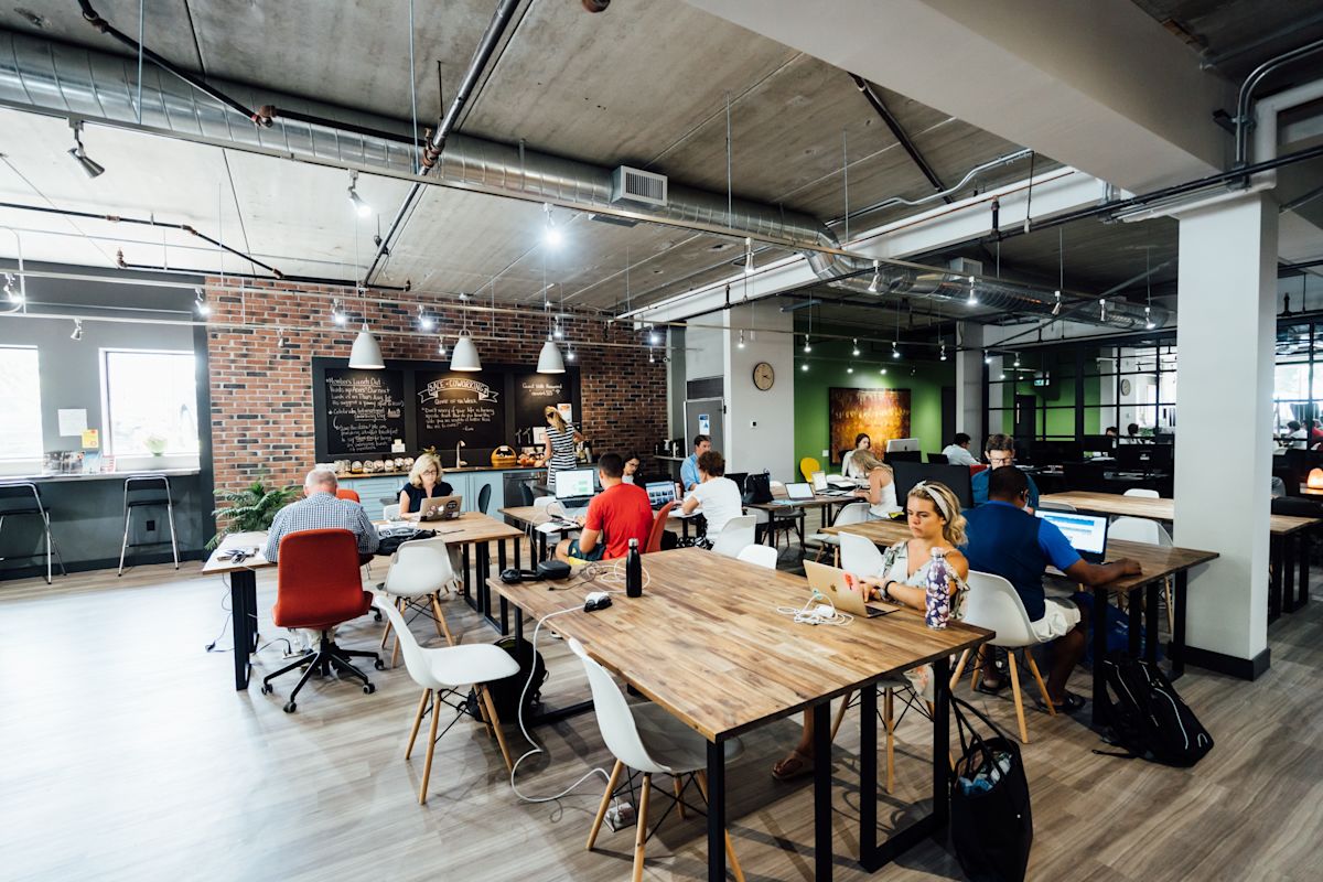 A modern co-working space at Luke Street 78a in London with people working at shared desks.