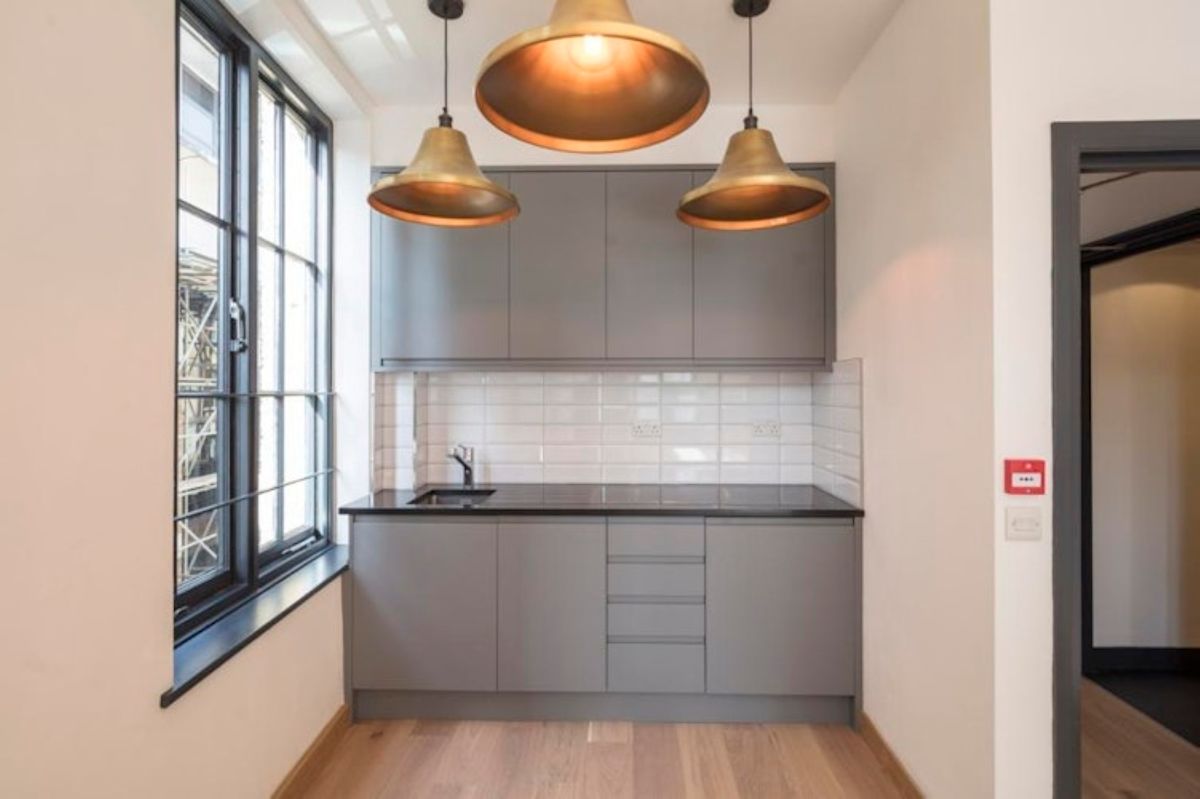 Modern kitchen interior with grey cabinets and pendant lighting on Luke Street 78a, London.