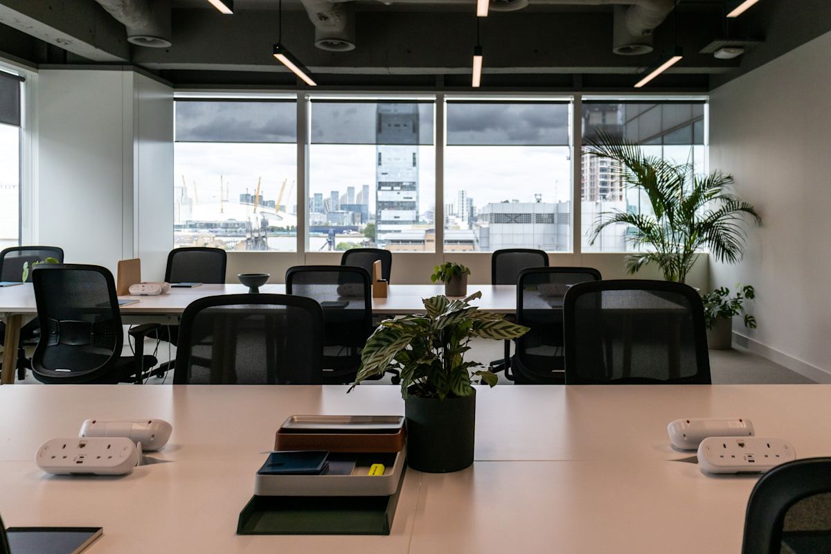 Modern office space with view of London's skyline through large windows.
