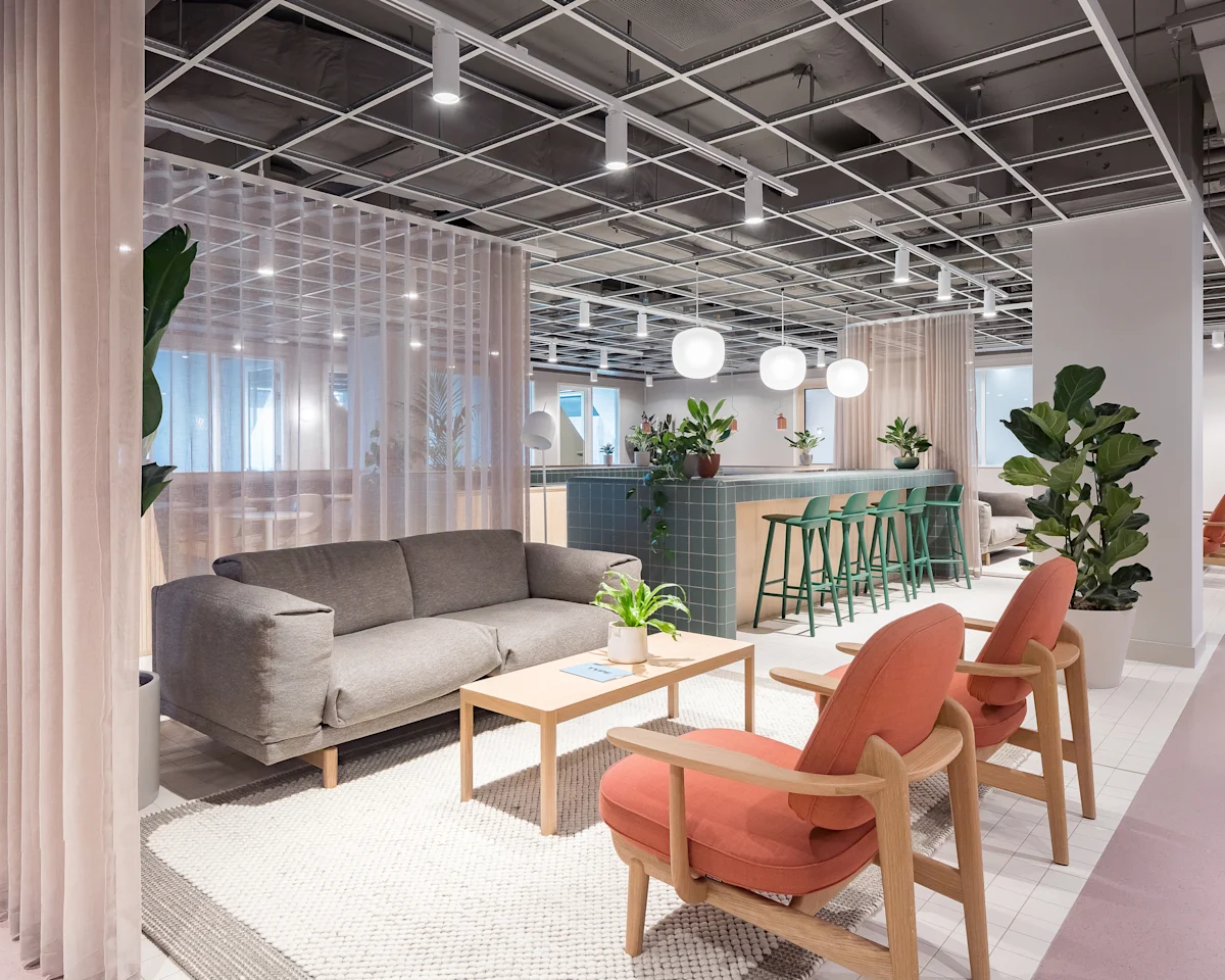 Modern office lounge area at Marsh Wall 77 in London with cozy seating and plants.