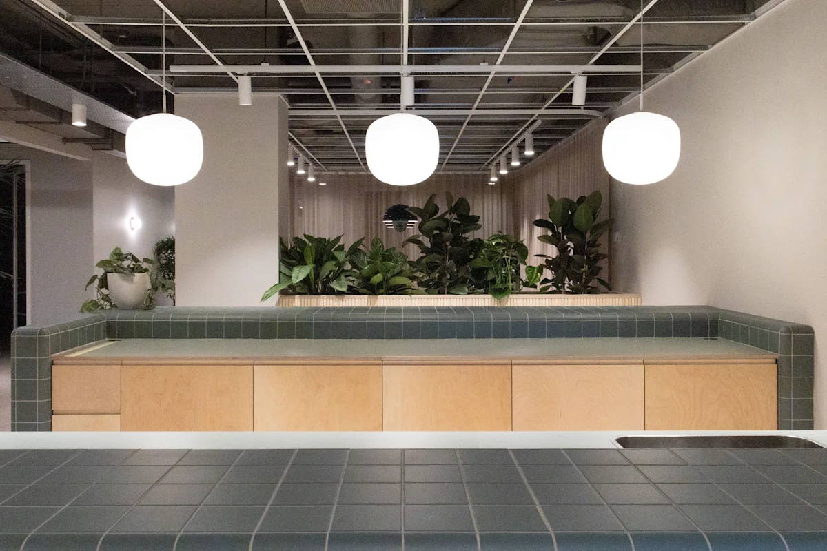 Modern interior space in Marsh Wall 77, London with greenery and spherical ceiling lights.