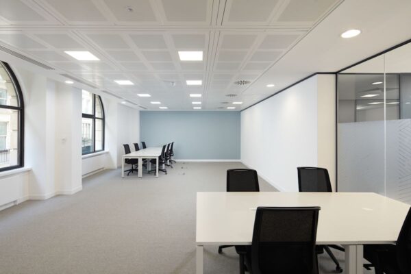 A spacious, modern office interior with large windows and several desks with chairs at 35 New Broad Street in London.